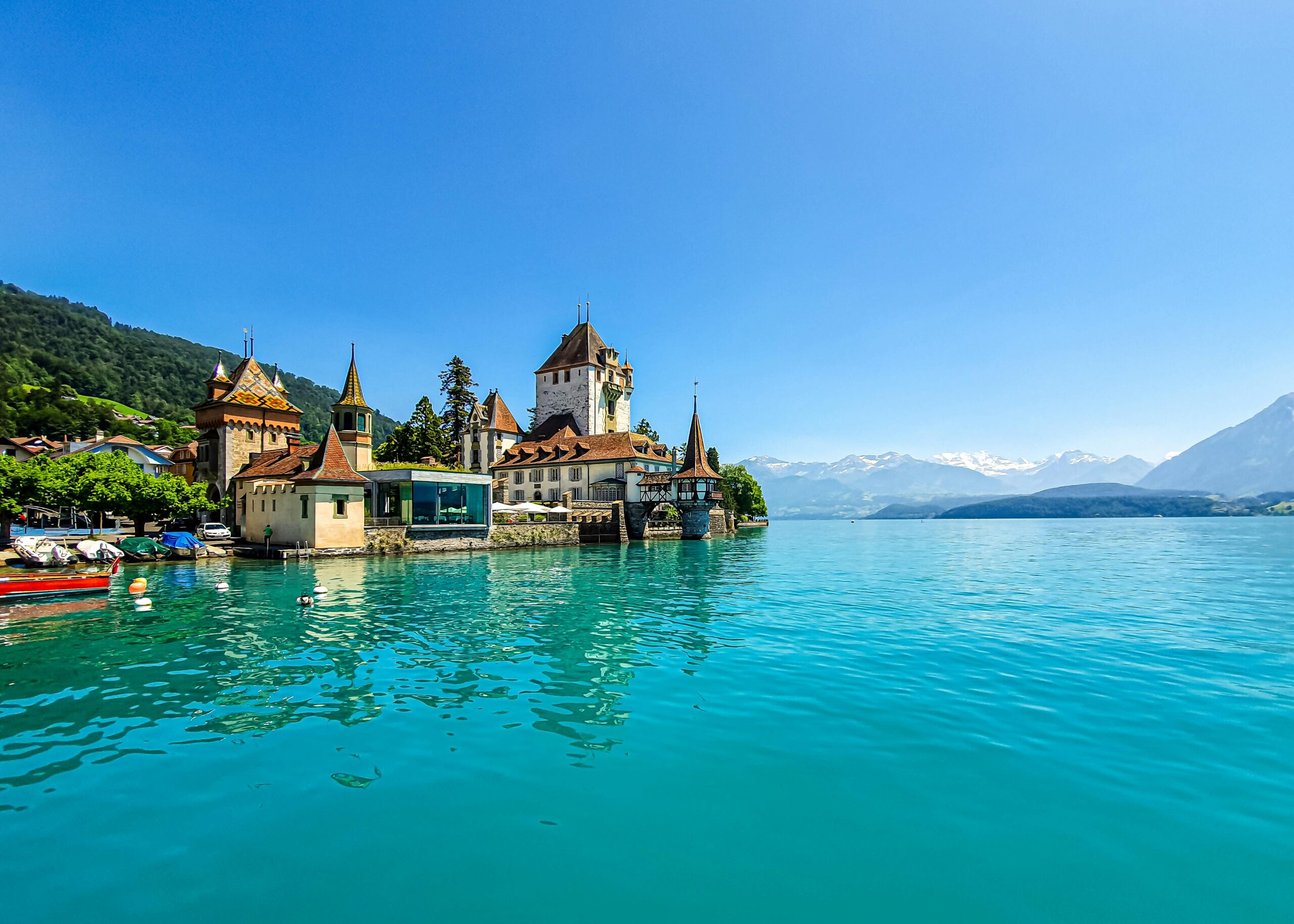 Experience the enchanting Oberhofen Castle on the turquoise shores of Lake Thun in Switzerland.