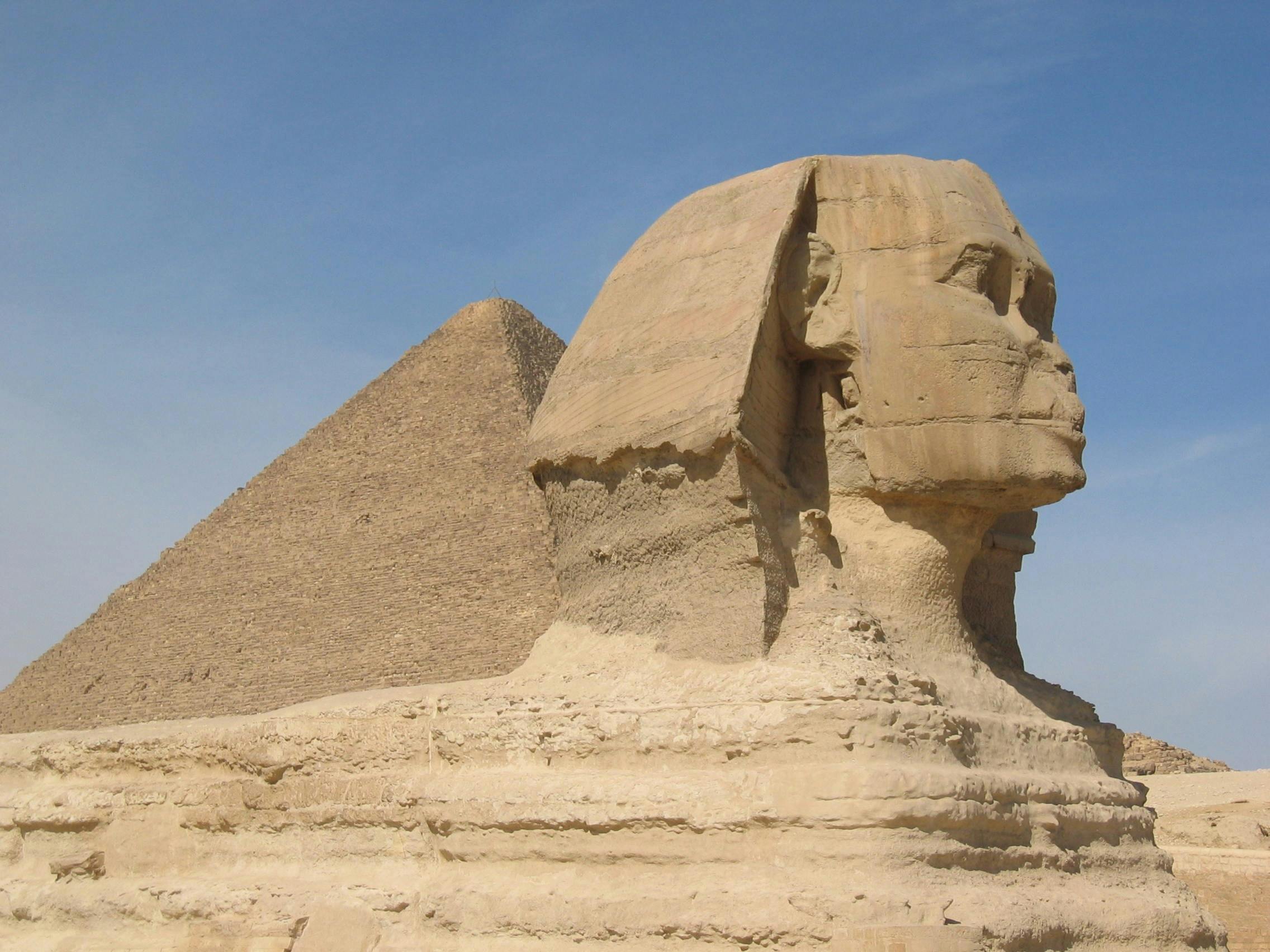 Iconic view of the Great Sphinx and Pyramid of Giza in Egypt under a clear sky.